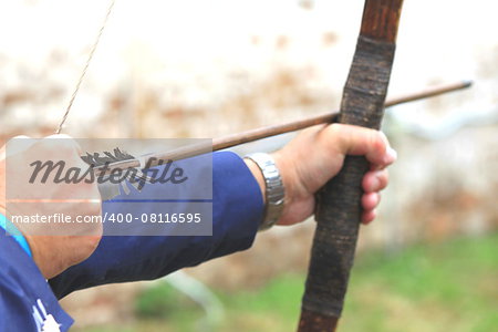 Businessman holding bow and shooting to archery target. Abstract photo.