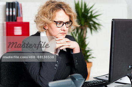 Serious businesswoman sitting with hands on chin