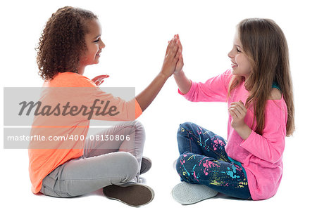 Pretty girls sitting on the floor and playing