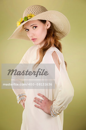 woman wearing hat with flowers on light green background