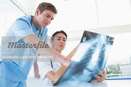 Doctors looking at X-ray in medical office