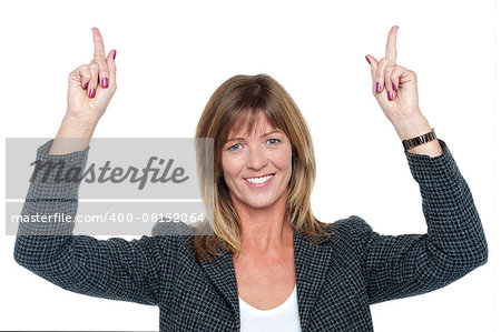 Pretty corporate lady pointing upwards with both her arms raised.