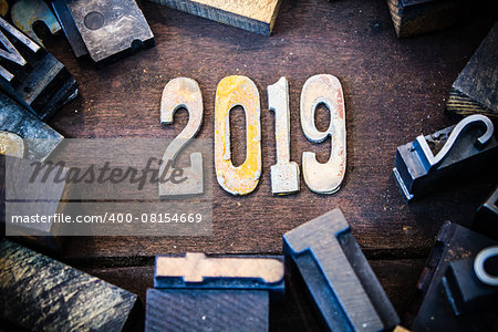 The year 2019 written in rusted metal letters surrounded by vintage wooden and metal letterpress type.