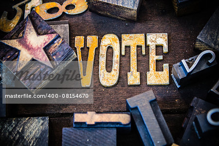 The word VOTE written in rusted metal letters surrounded by vintage wooden and metal letterpress type.