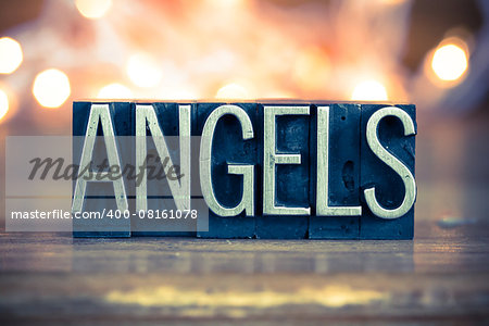 The word ANGELS written in vintage metal letterpress type on a soft backlit background.