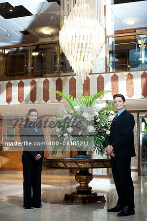 Smartly dressed front office executives posing under a chandler with flower vase as a centerpiece