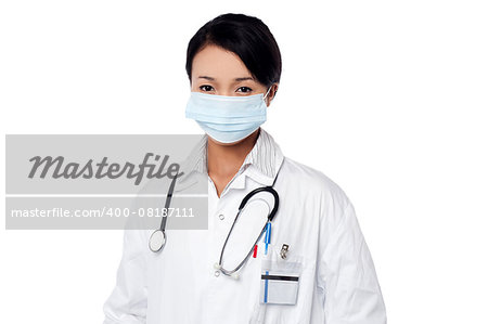 Young female physician covering her face with surgical mask