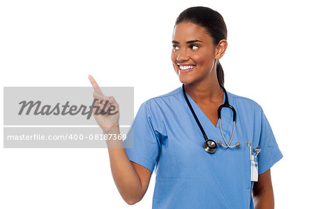 Young smiling female physician looking and pointing away.