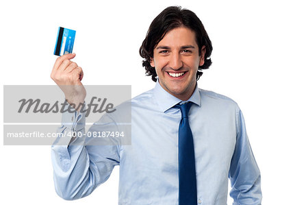 Smiling young corporate man holding up his credit card