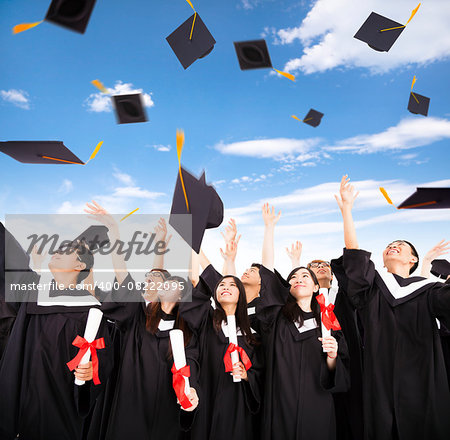 happy students throwing graduation caps into the Air