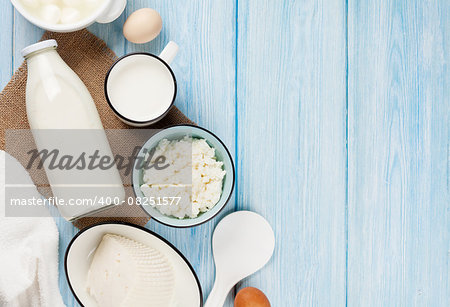 Dairy products on wooden table. Sour cream, milk, cheese, eggs and yogurt. Top view with copy space