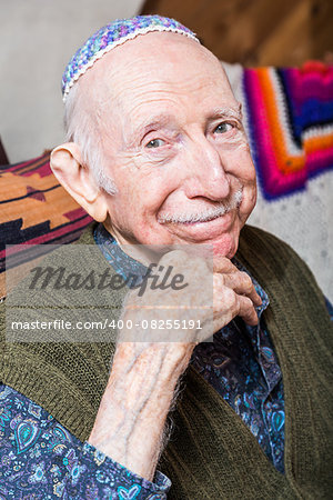 Elderly gentleman wearing a yarmulke smiling at the camera