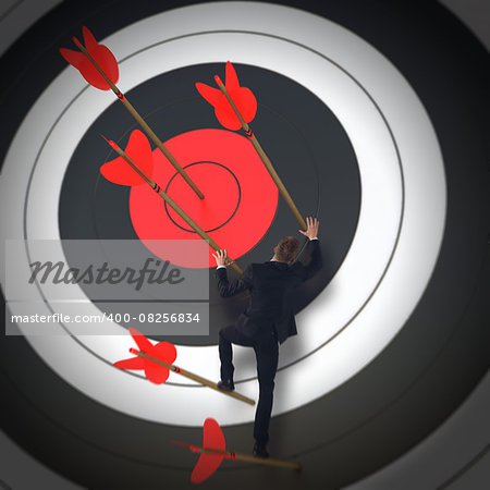 Man climbs the arrows of a target