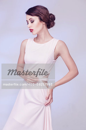 portrait of beauty woman in white dress isolated over light blue studio background