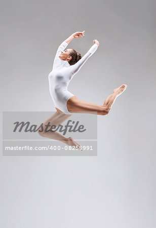 Young slim gymnast in studio