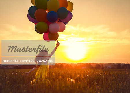 Little girl with balloons on the Sunset