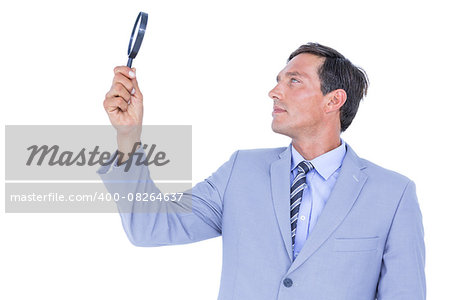 concentrated businessman using magnifying glass on white background