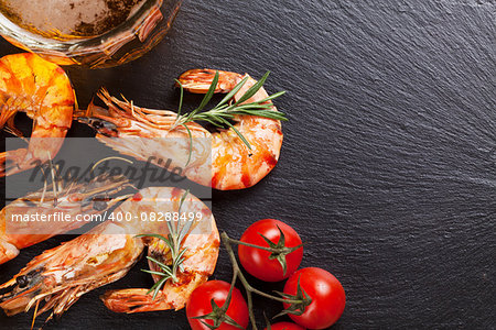 Beer mug and grilled shrimps on stone plate. Top view with copy space