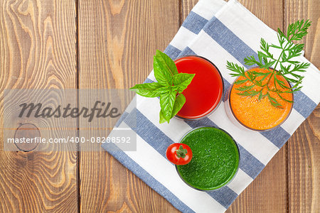 Fresh vegetable smoothie on wooden table. Tomato, cucumber, carrot. Top view with copy space