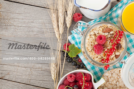 Healty breakfast with muesli, berries and orange juice. View from above on wooden table with copy space