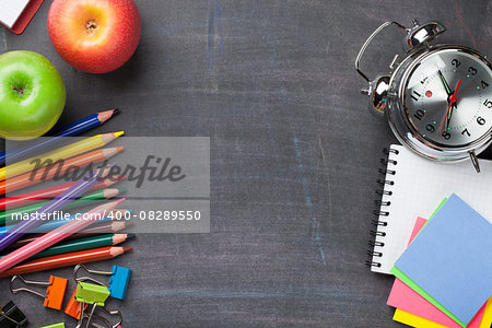 School and office supplies on blackboard background. Top view with copy space