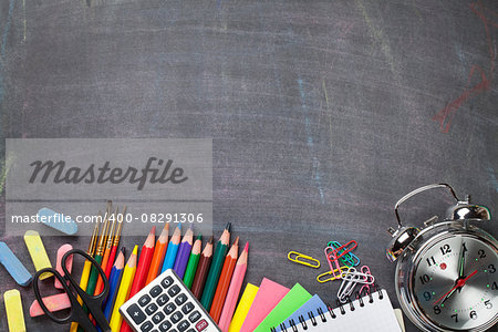 School and office supplies on blackboard background. Top view with copy space