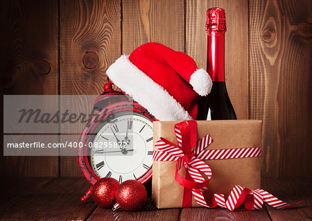 Christmas gift box, alarm clock, santa hat and champagne bottle