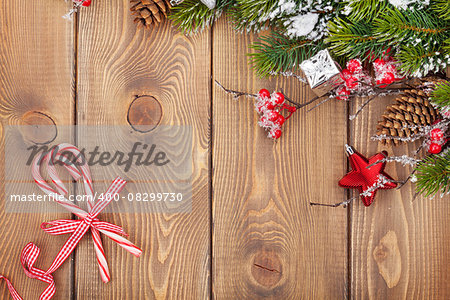 Christmas wooden background with snow fir tree and holly berry