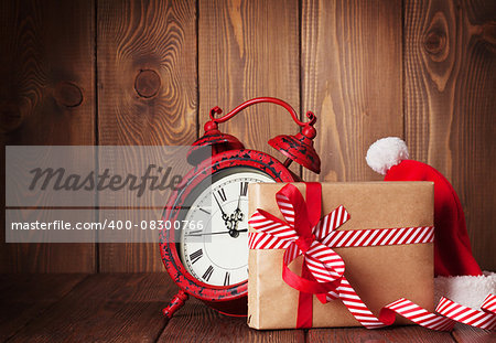 Christmas gift box, alarm clock and santa hat. View with copy space
