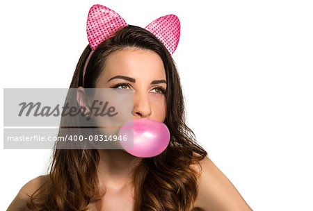 Hot playful brunette model blowing pink chewing bubble gum looking up isolated on white