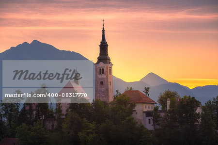 Catholic Church in Bled Lake, Slovenia at Sunrise with Mountains in Background