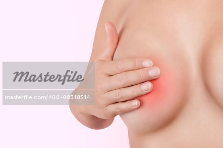 Breast self examination. Beautiful young woman touching her breast isolated on pink background. Sensual feminine beauty and health. Breast cancer.