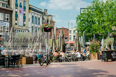 Eindhoven, Netherlands - May 24, 2015: People sitting at outdoors restaurant in the main square of Eindhoven in sunny spring day. It is popular touristic place, with plenty of restaurants, bars, stores and clubs