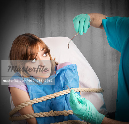 Frightened girl tied to the chair dentist