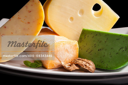 Colorful culinary cheese variation on black background. Gourmet cheese eating, modern minimal contemporary style.