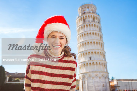 Young, itching from energy and searching for excitement. I'm going to Christmas trip to Italy. It is a no-brainer. Portrait of happy woman in Santa hat in front of Leaning Tour of Pisa.