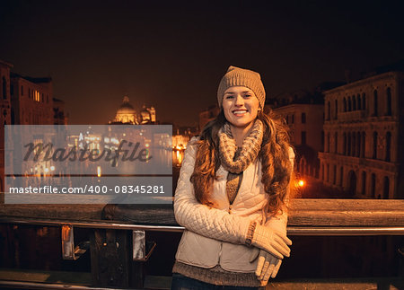 Tune in for charming winter time in Venice, Italy. Happy young woman standing on a bridge overlooking Grand canal