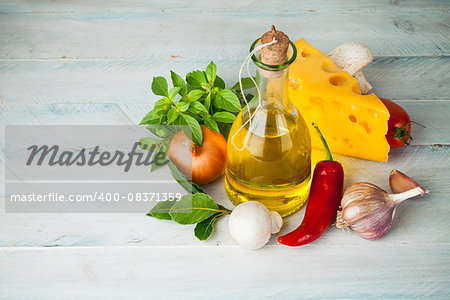 Olive oil with spices and vegetables on wooden board
