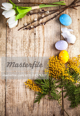 Easter still life with copyspace and spring flowers on wooden board