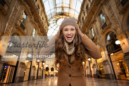 Get ready to making your way through shopping addicted crowd. Huge winter sales in Milan just started. Happy young woman in Galleria Vittorio Emanuele II rejoicing start of sales