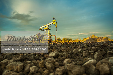 Oil pump jacks at sunset sky background.