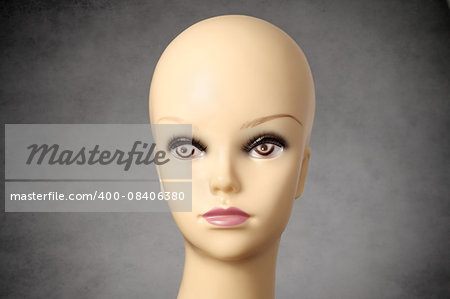 Closeup of a female mannequin head on gray background