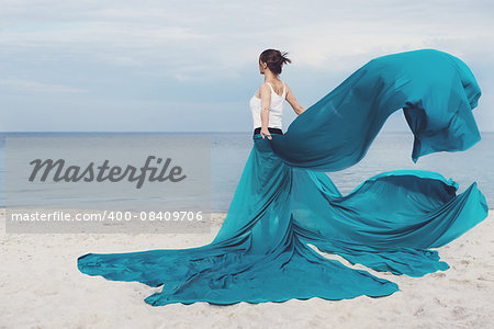Beautiful Girl With colour fabric on The Beach. Travel and Vacation. Freedom Concept.