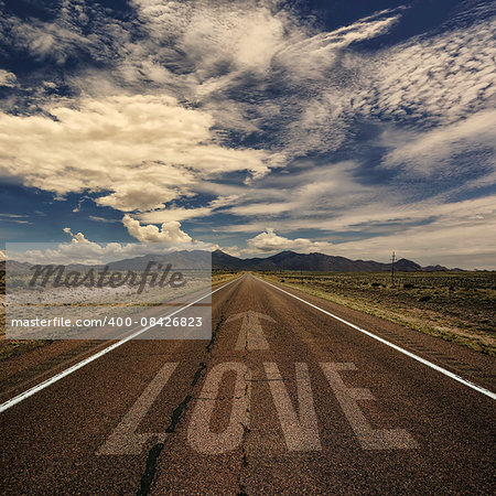 Conceptual image of desert road with the word love and arrow