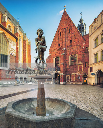 Brass boy fountain sculpture on Mariacki Square Old Town of Krakow Poland