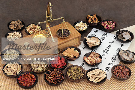 Chinese medicine ingredients with scales and calligraphy on rice paper. Translation read as chinese herbal medicine as increasing the bodys ability to maintain body and spirit health and balance energy.