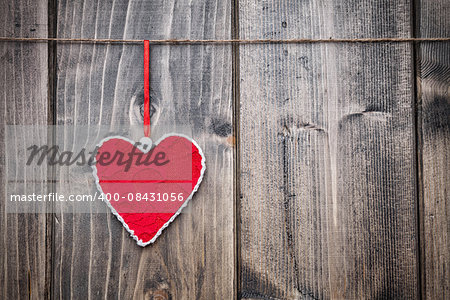 Love concept. Heart hanging on a string, shot on wooden background