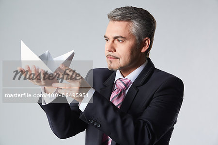 Portrait of businessman holding paper boat. The concept idea