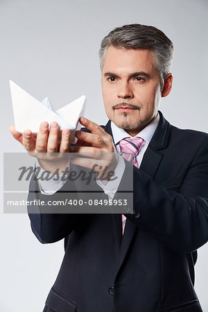 Portrait of businessman holding paper boat. The concept idea