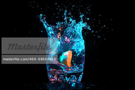 Colorful cocktail with lemon slice on the black background